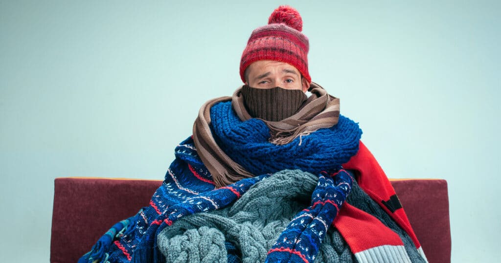 Man is freezing because his HVAC is blowing cold air in winter.
