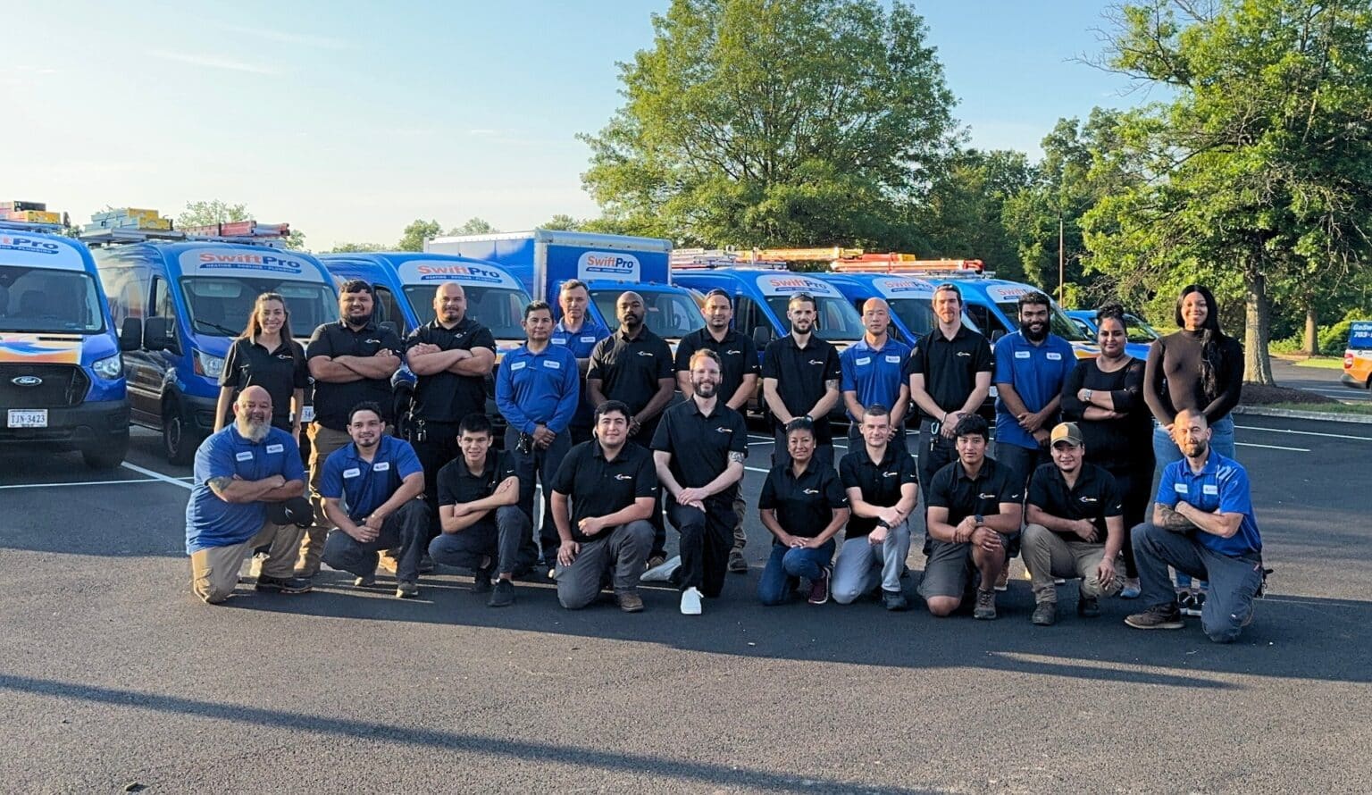 The SwiftPro Heating, Cooling and Plumbing team standing in front of their fleet of wrapped service vans in Northern Virginia