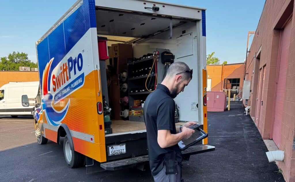 SwiftPro heating, cooling and plumbing service van with technician and tools for AC repair in