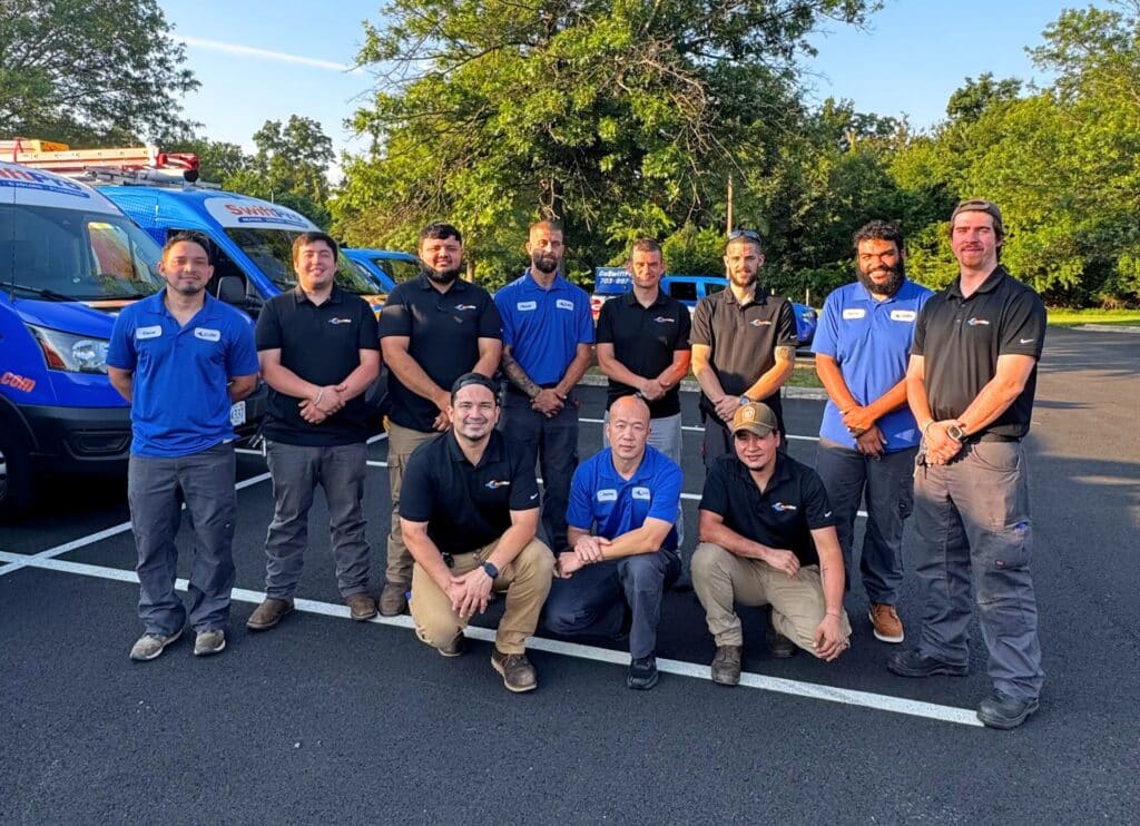The SwiftPro Heating, Cooling & Plumbing team in front of their branded service vans in Chantilly, Virginia