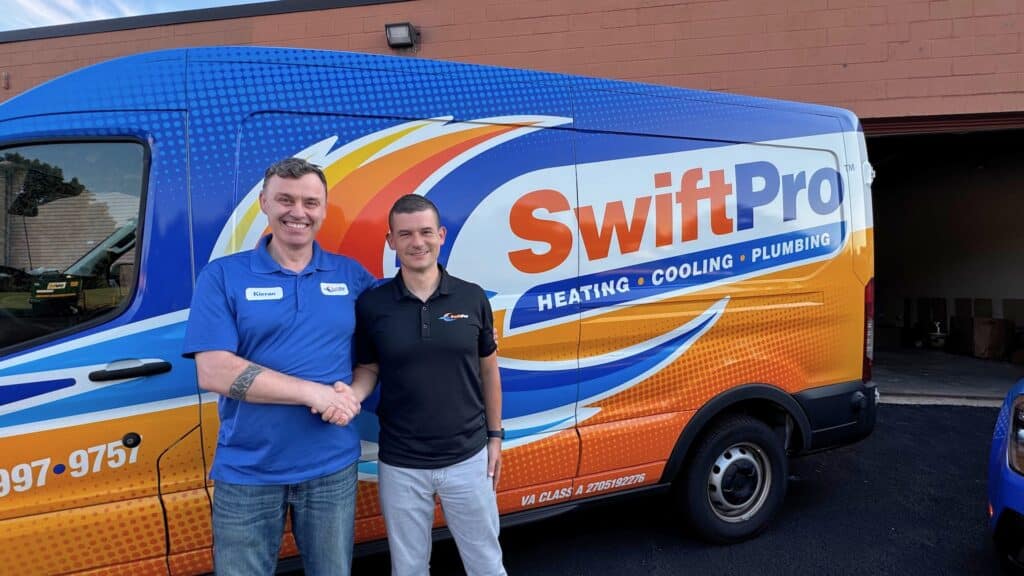 SwiftPro HVAC and plumbing technicians standing with company van in Northern Virginia.