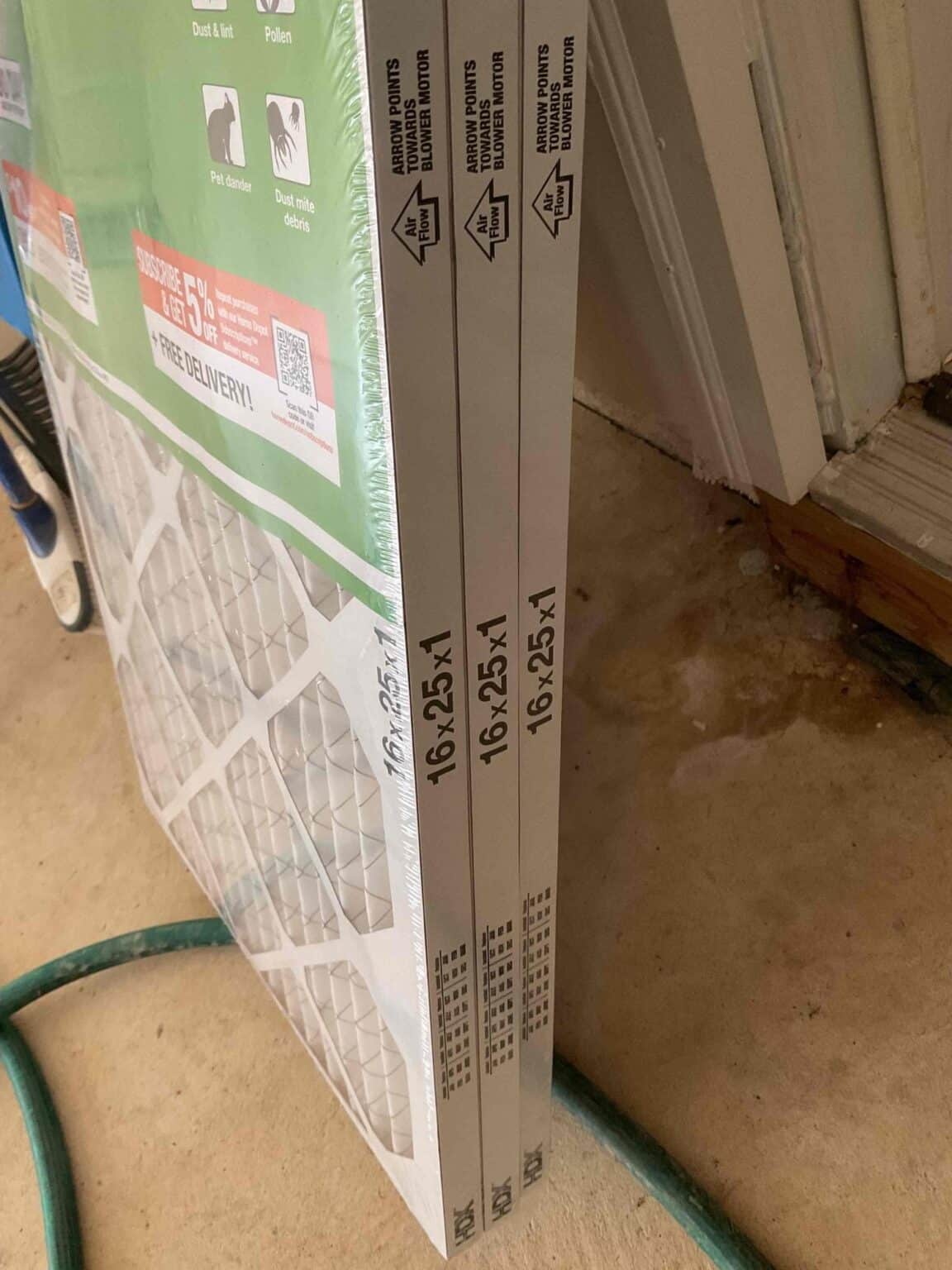 New 16x25x1 pleated air filters in their boxes, leaning against a wall before installation