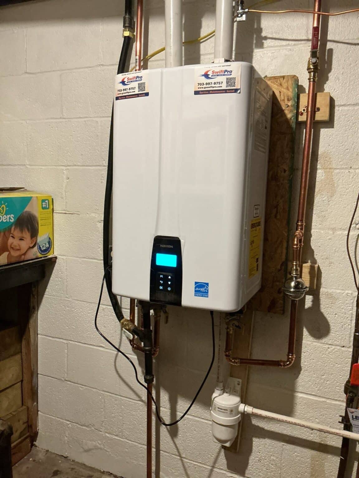 A wall-mounted Navien gas tankless water heater installed by SwiftPro in a Northern Virginia basement, with new copper lines and PVC venting