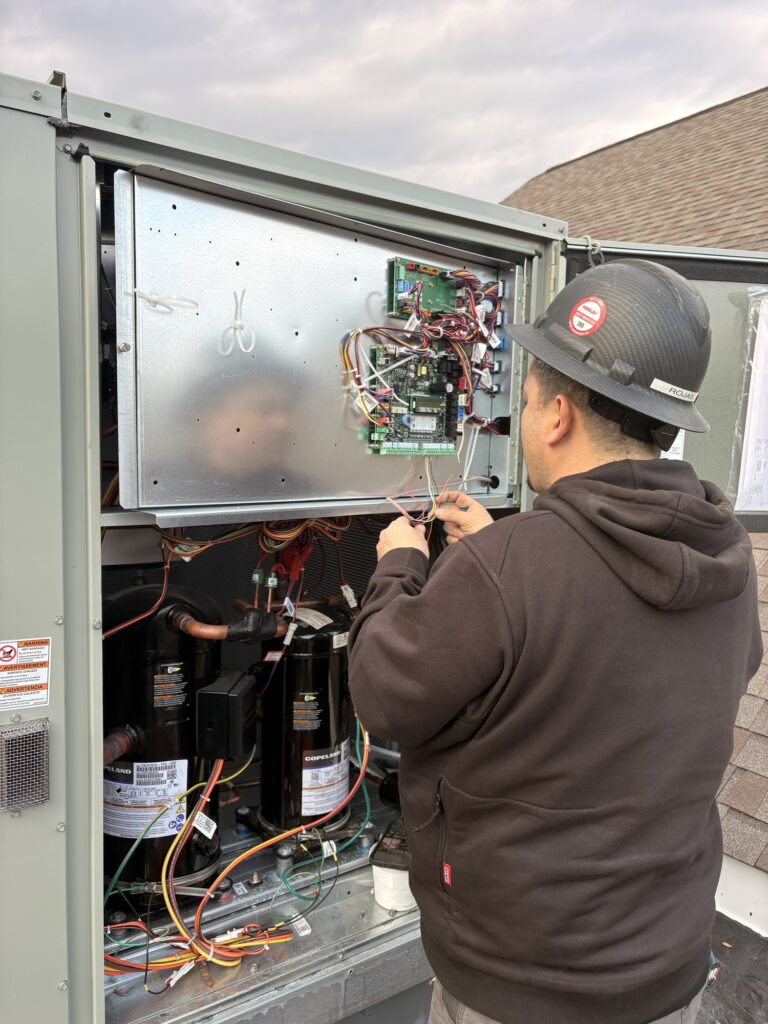 A SwiftPro technician working inside the opened cabinet of an outdoor condensing unit