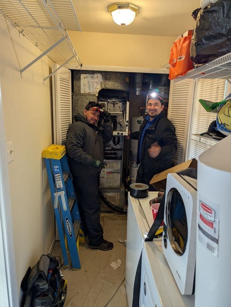 Two SwiftPro technicians working in the laundry and utility room of a Northern Virginia home
