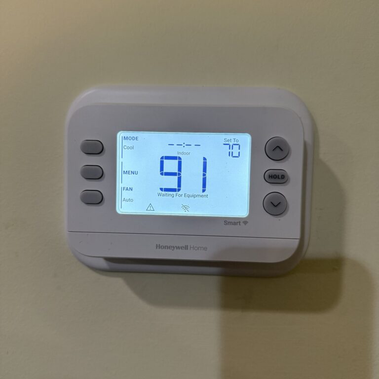 A Honeywell thermostat in a Northern Virginia home in cool mode, reading 91 degrees indoors with the setting at 70 and the screen showing Waiting For Equipment