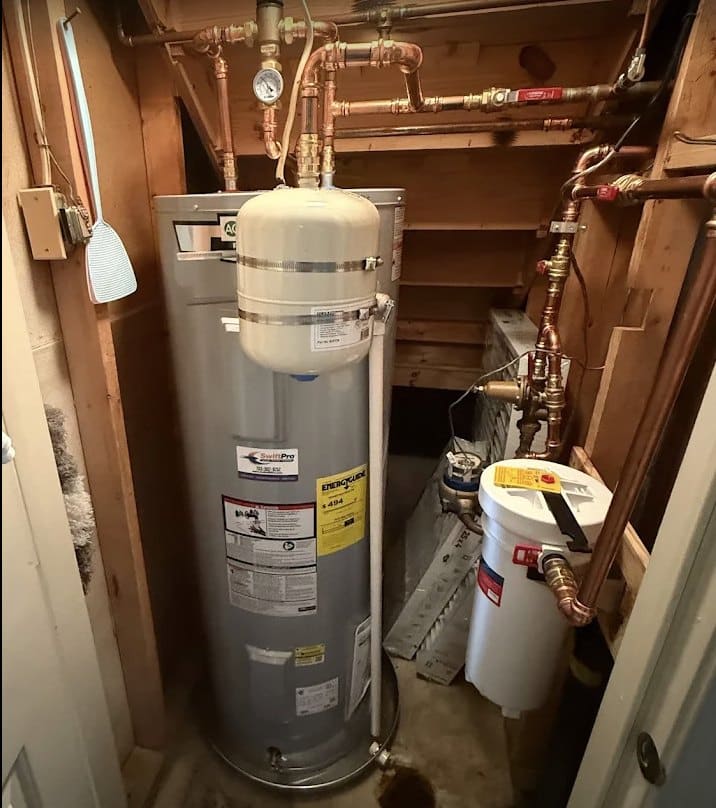 A tank water heater with its expansion tank and shutoff in a Northern Virginia utility space
