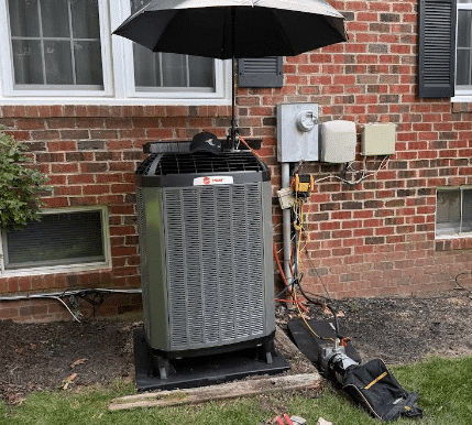Outdoor air conditioner condenser installed by SwiftPro beside a brick Northern Virginia home