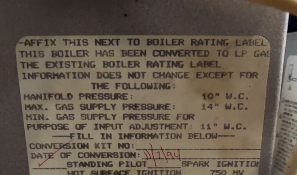 A gas conversion label on a Northern Virginia boiler showing a conversion date of January 1994, found by a SwiftPro technician on a service call