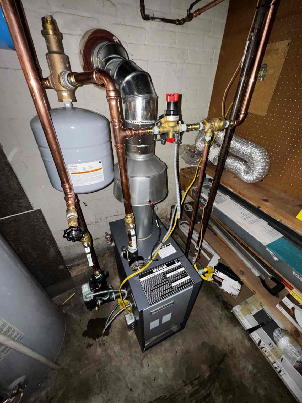 Close view of a SwiftPro boiler installation in Northern Virginia showing the expansion tank, automatic air vent, fill valve and the vent connector into the chimney