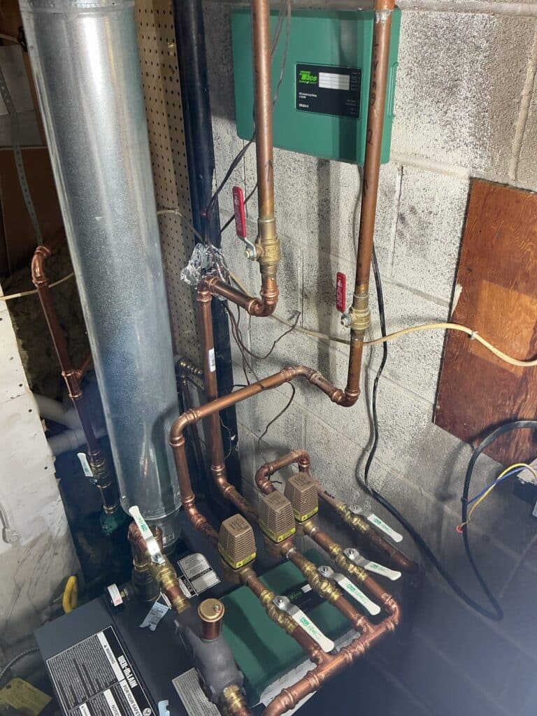 A new Weil-McLain gas boiler installed by SwiftPro in a Northern Virginia basement, with copper near-boiler piping and a bank of Taco zone valves feeding the heating loops