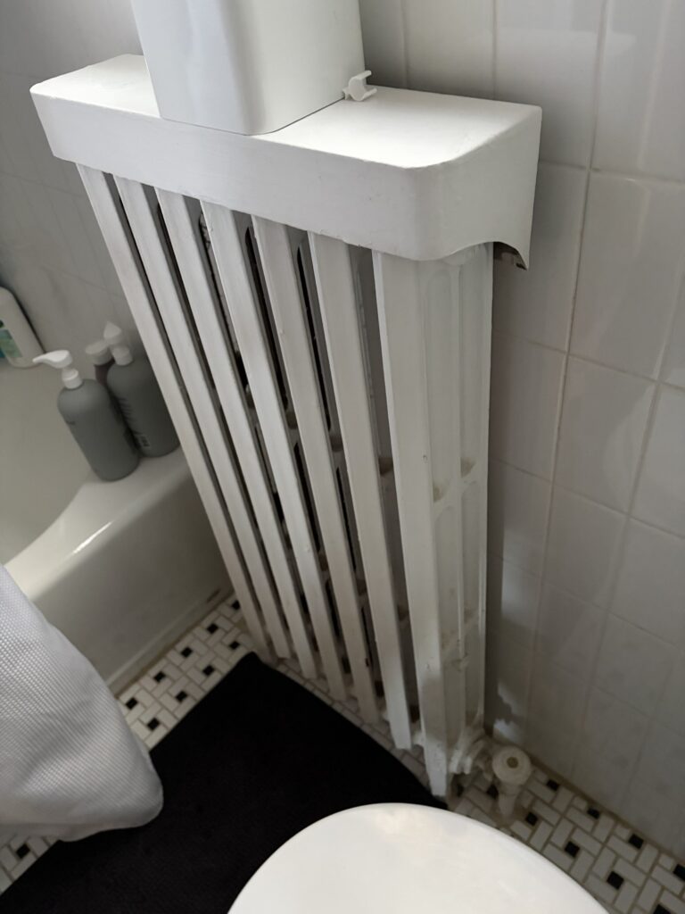 A painted cast iron radiator in a Northern Virginia home, the heat emitter on a hydronic boiler system