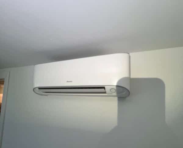 A wall-mounted ductless mini split indoor head installed high on an interior wall of a Northern Virginia home