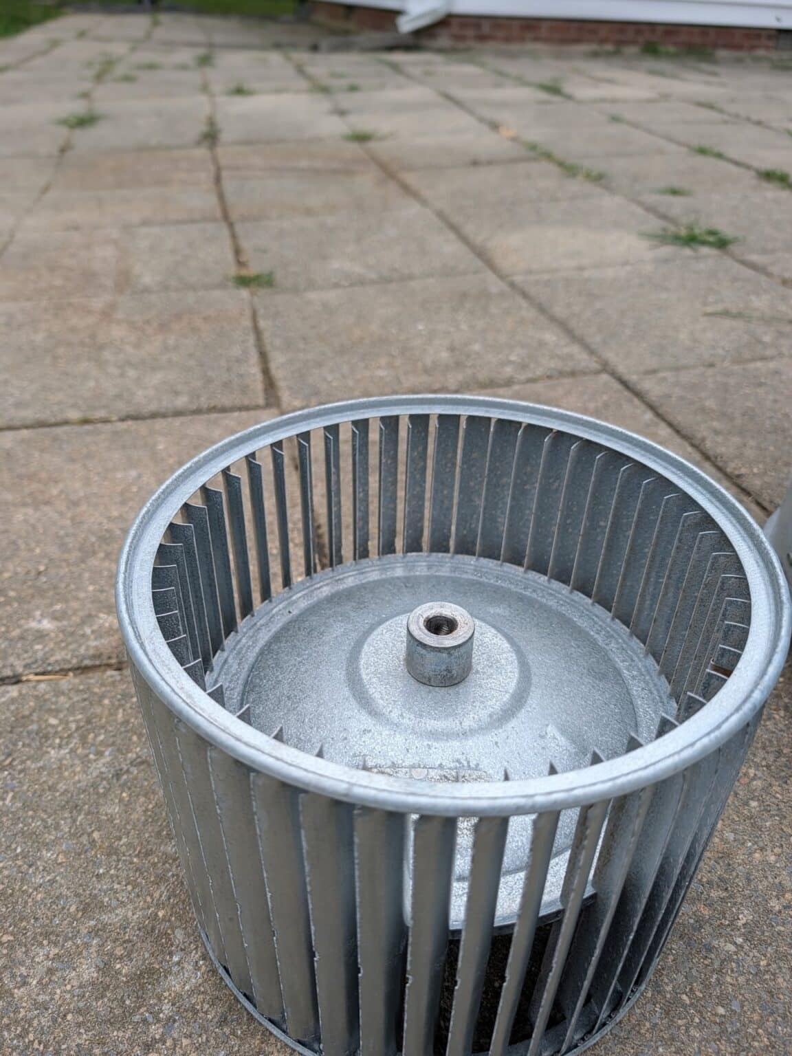 A furnace blower wheel after cleaning on a SwiftPro heating job in Northern Virginia, bare metal blades with the dust gone