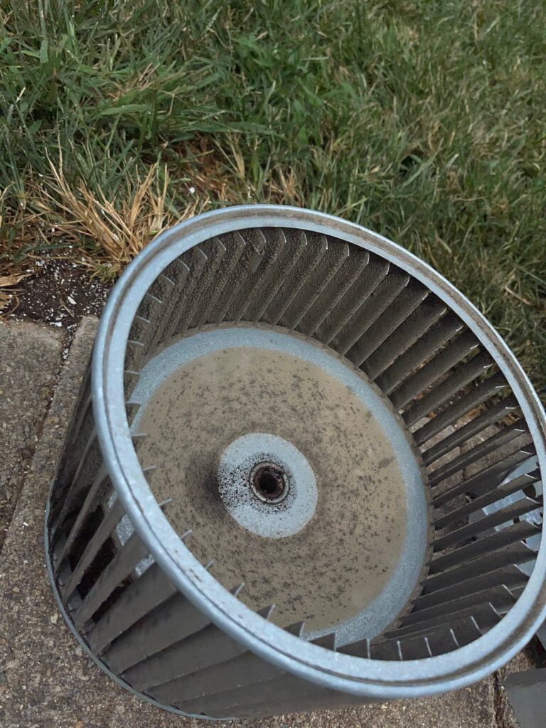 A dusty furnace blower wheel pulled out of a furnace on a SwiftPro heating job in Northern Virginia, before cleaning