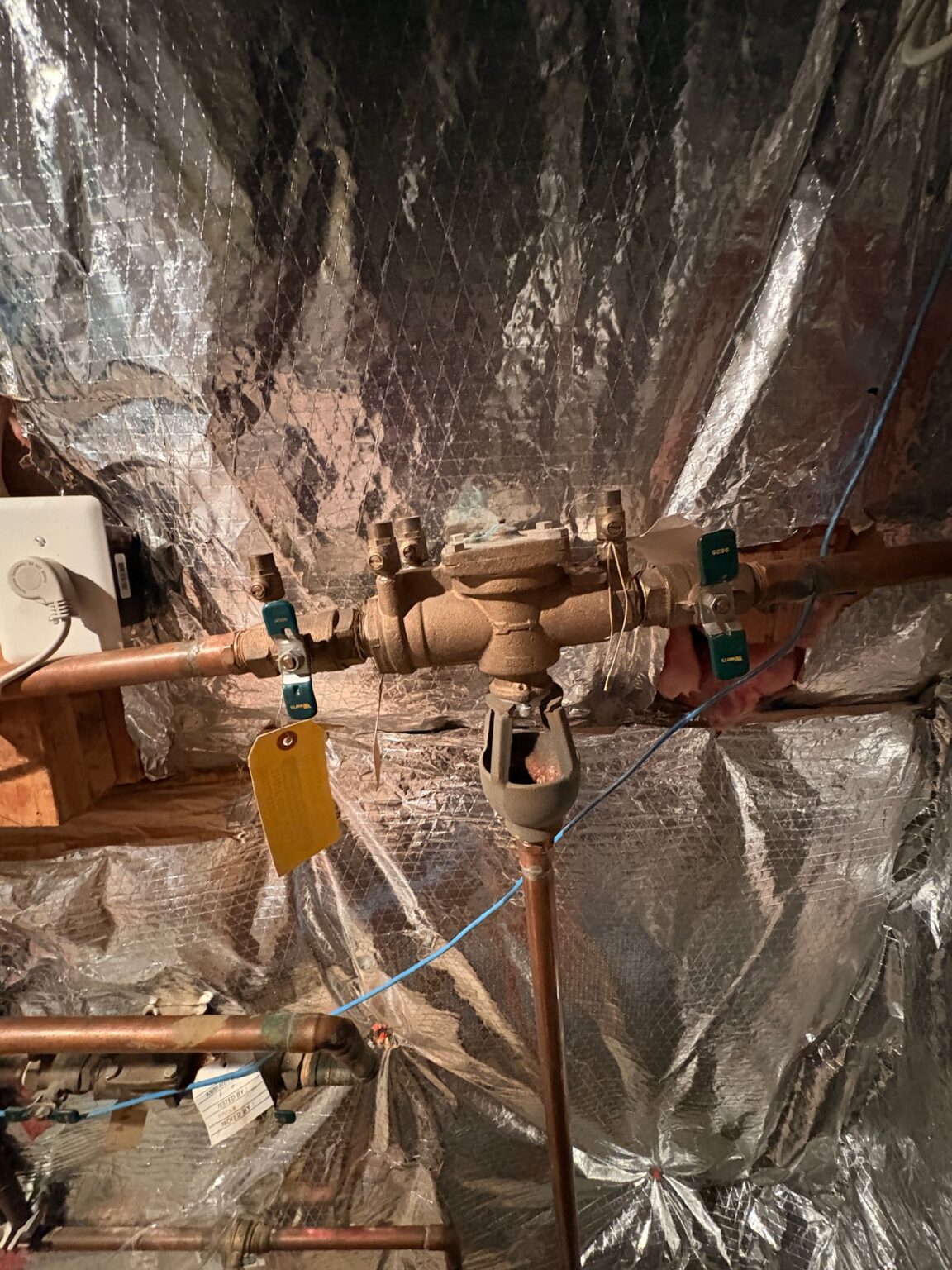 An old, corroded RPZ backflow preventer on the main water line in a Loudoun County basement, before SwiftPro replaced it