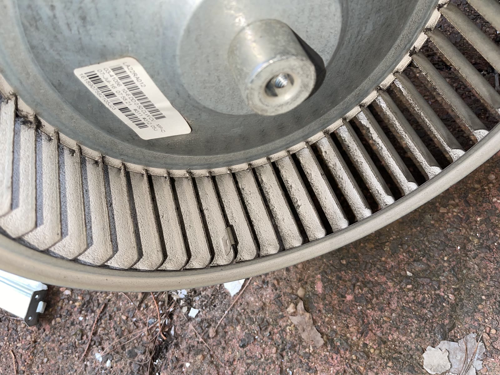 Closeup of dust coating the fins of a removed furnace blower wheel.
