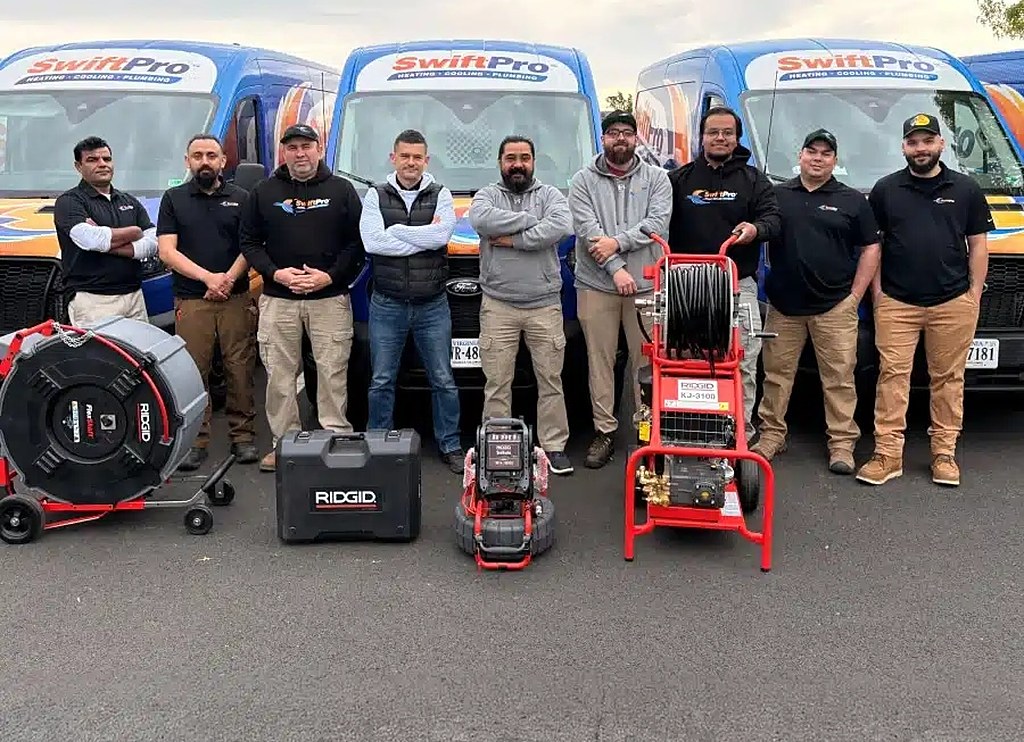 The SwiftPro crew in front of three wrapped SwiftPro vans in Northern Virginia, with their drain machine, sewer camera and water jetter