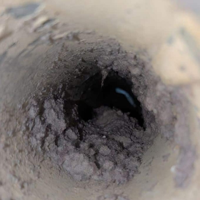 Looking down a dryer vent line packed with lint before cleaning, on a SwiftPro job in Ashburn, Virginia
