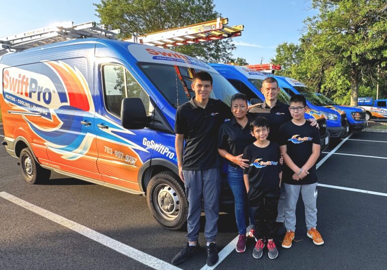 A family in SwiftPro shirts standing beside the SwiftPro vans
