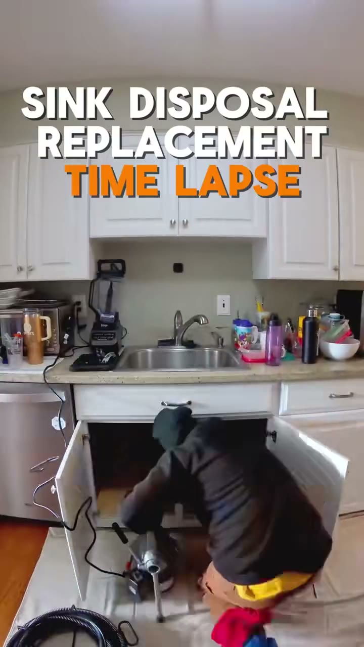 Fixed-camera timelapse of a tech in a beanie replacing a kitchen garbage disposal under a sink, with text "Total time: 2 hours", "The cause of the problem", "Be mindful of what goes down your sink" an