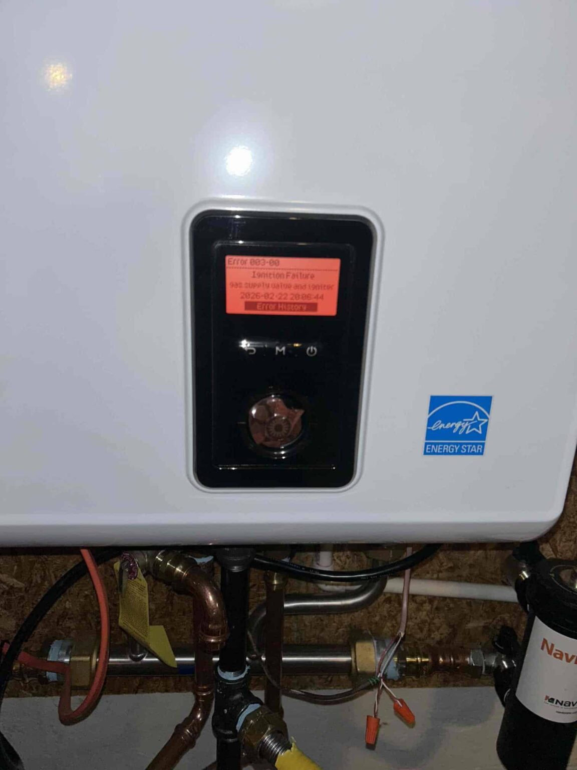 A Navien tankless water heater display showing Error 003-00, an ignition failure, in a Northern Virginia home