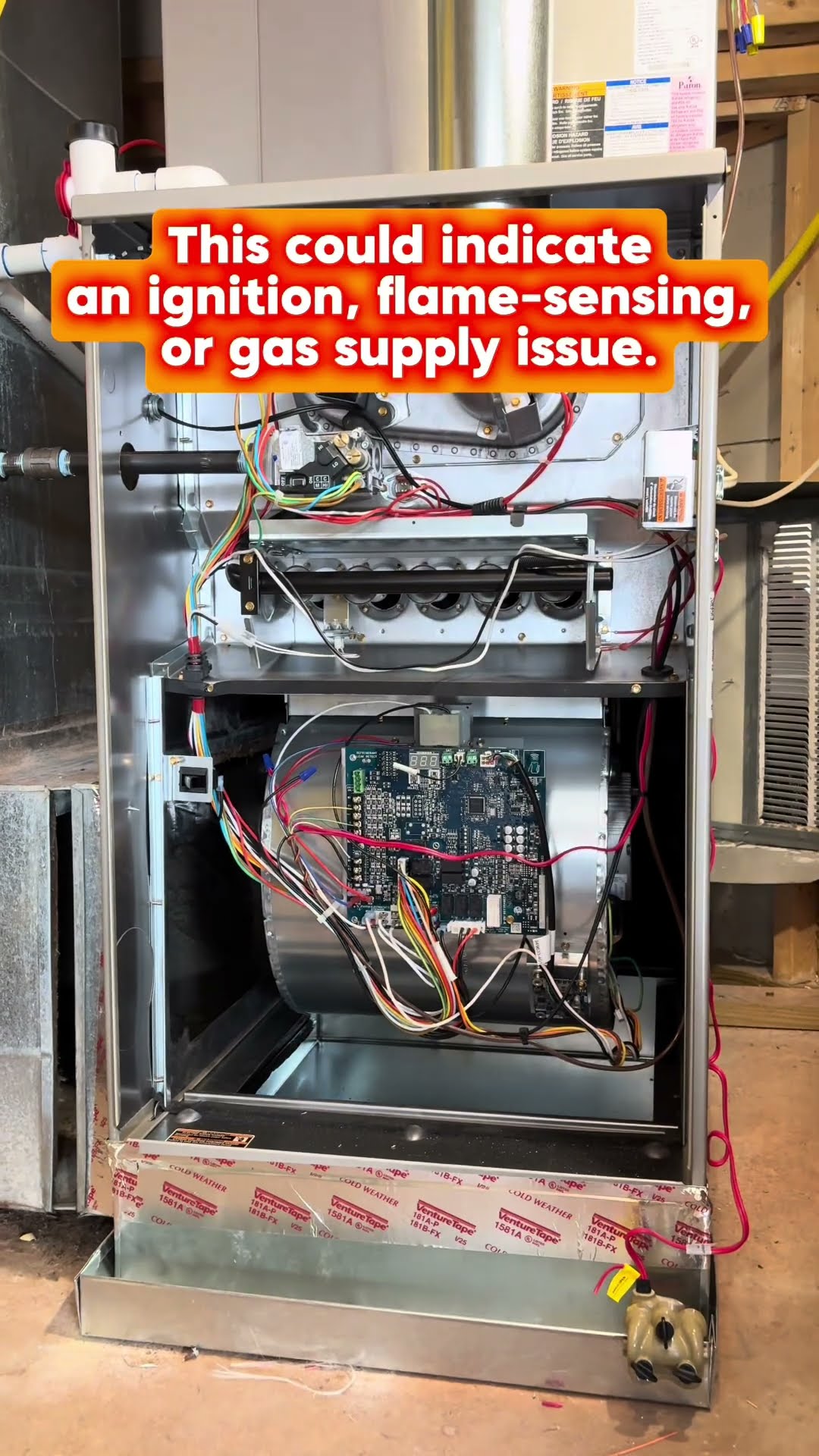 A furnace in a basement with the front panels off showing the burners, gas valve, control board and blower.