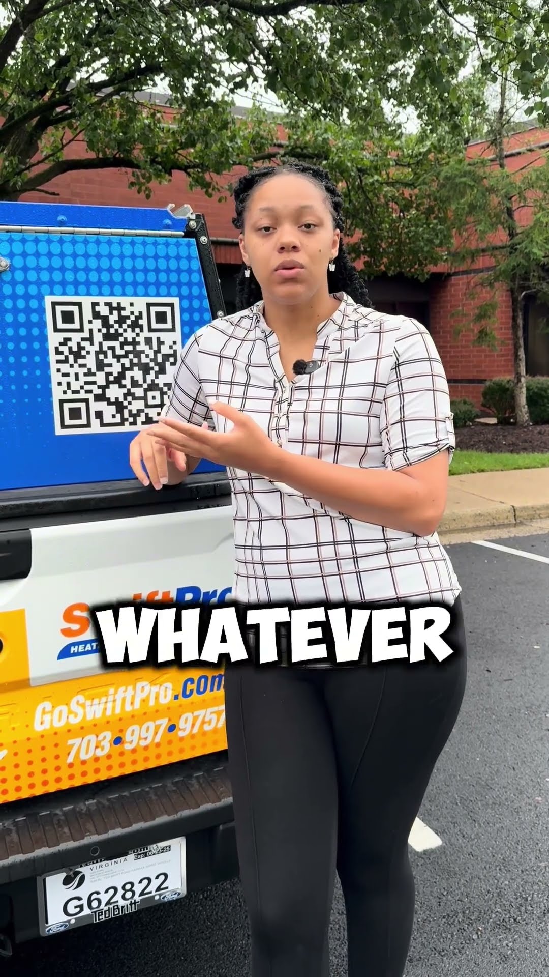 A SwiftPro staff member in a plaid blouse stands at the tailgate of a SwiftPro-wrapped Ford pickup (QR code panel, GoSwiftPro.com, 703-997-9757) in an office parking lot and explains when to call your
