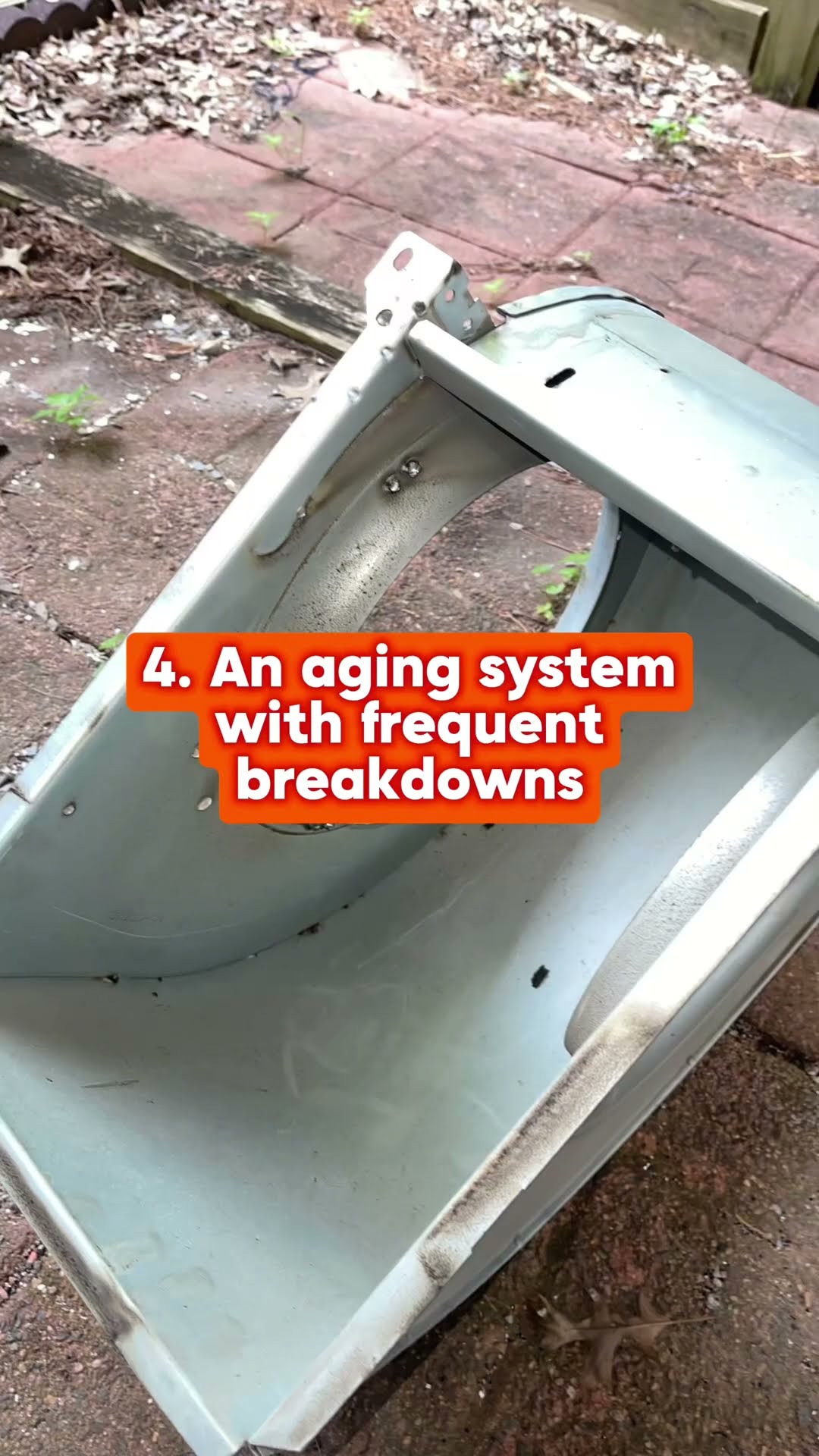 An old furnace blower housing lies on a patio under a list of furnace replacement signs (aging system with frequent breakdowns).