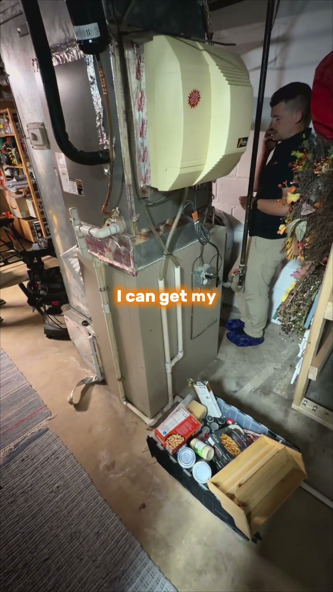 In-home assessment, part 2 of a series: an older homeowner in a blue t-shirt points out where a line runs in his unfinished basement to a SwiftPro rep in a black polo and khakis.